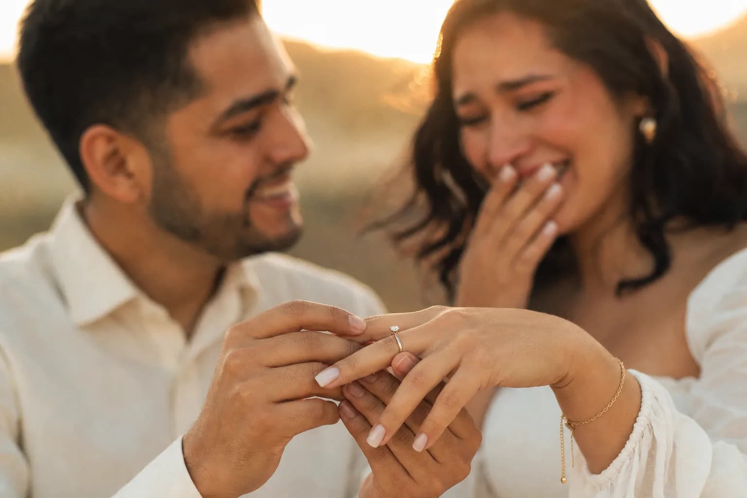 Pareja en la propuesta: él pone el anillo de compromiso donde se pone, en el dedo anular, ella emocionada