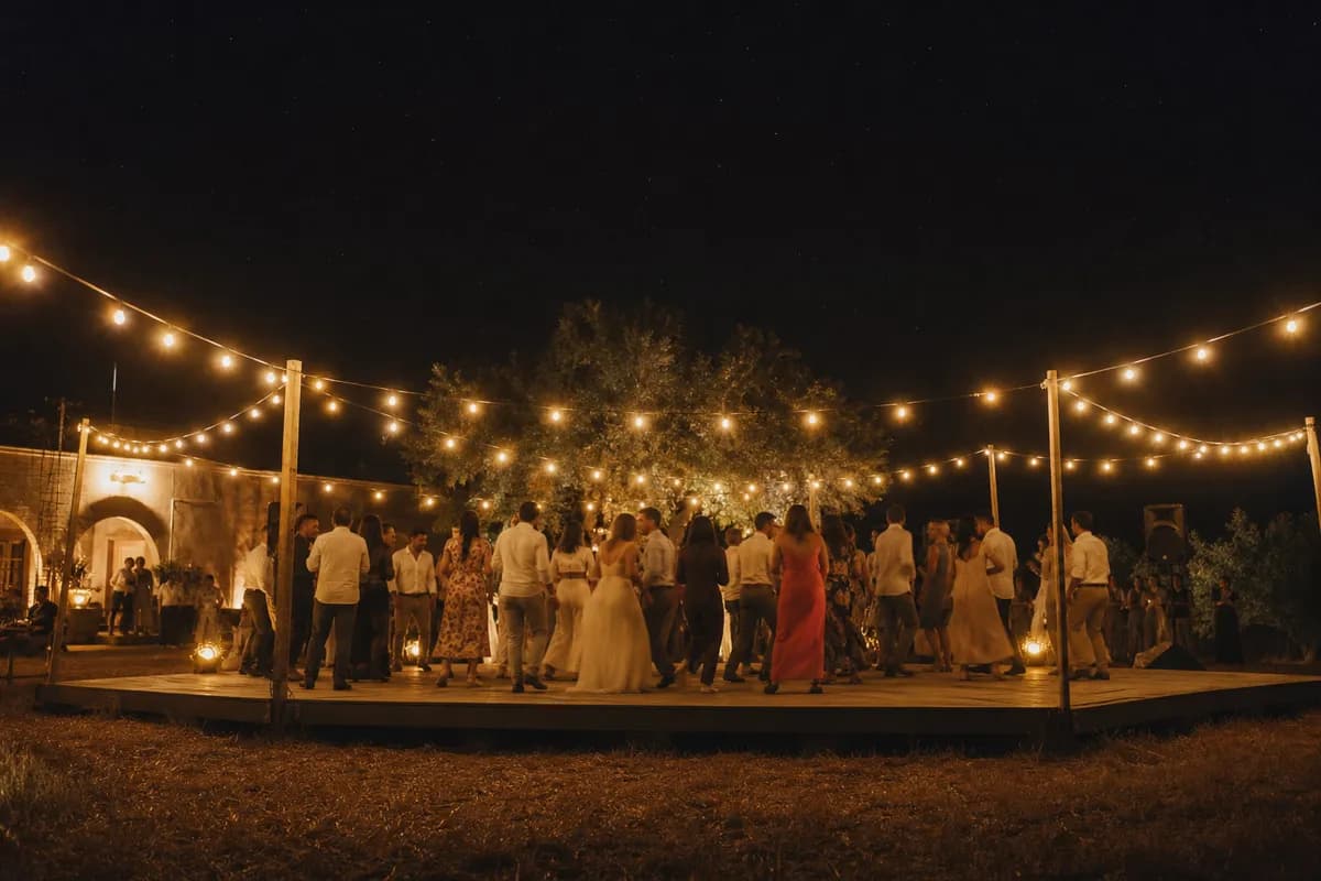 Pista de baile nocturna al aire libre con luces cálidas en boda de rancho