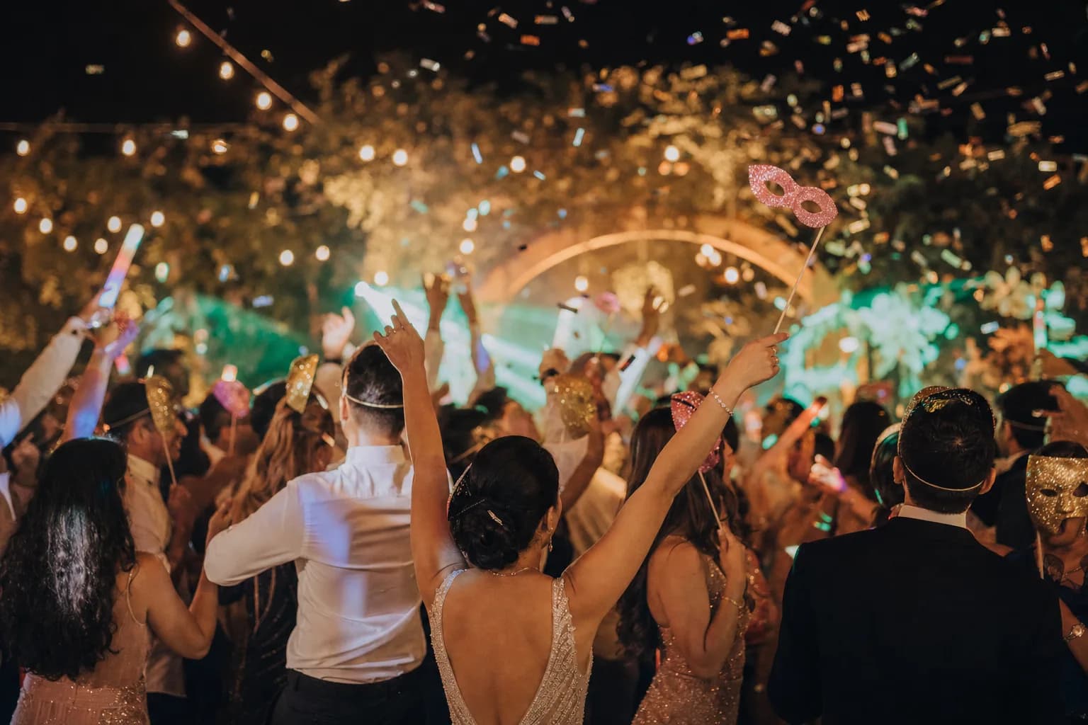 Hora loca de boda con invitados bailando, máscaras brillantes y luces LED de colores