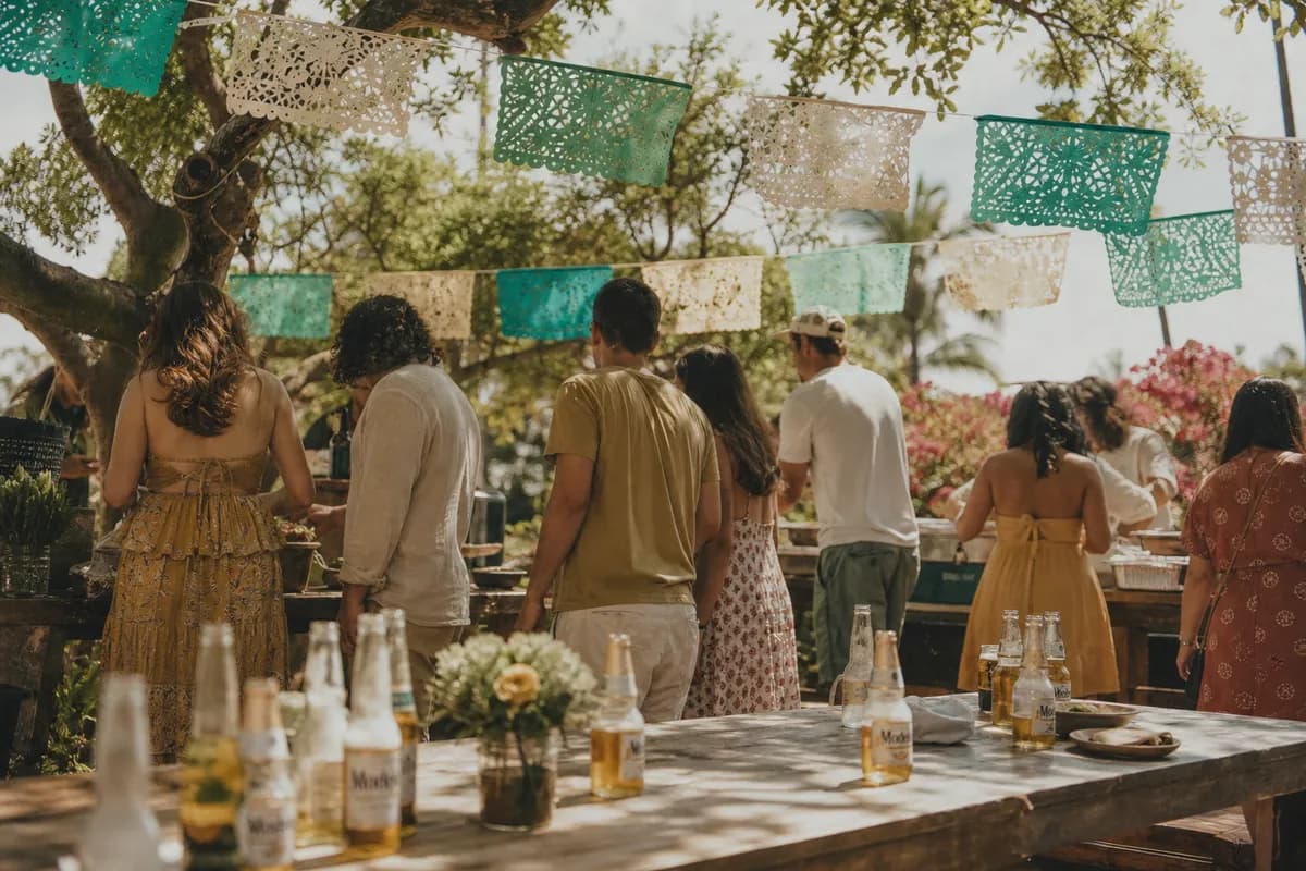 Invitados disfrutando una taquiza al aire libre en la tornaboda con papel picado y cervezas