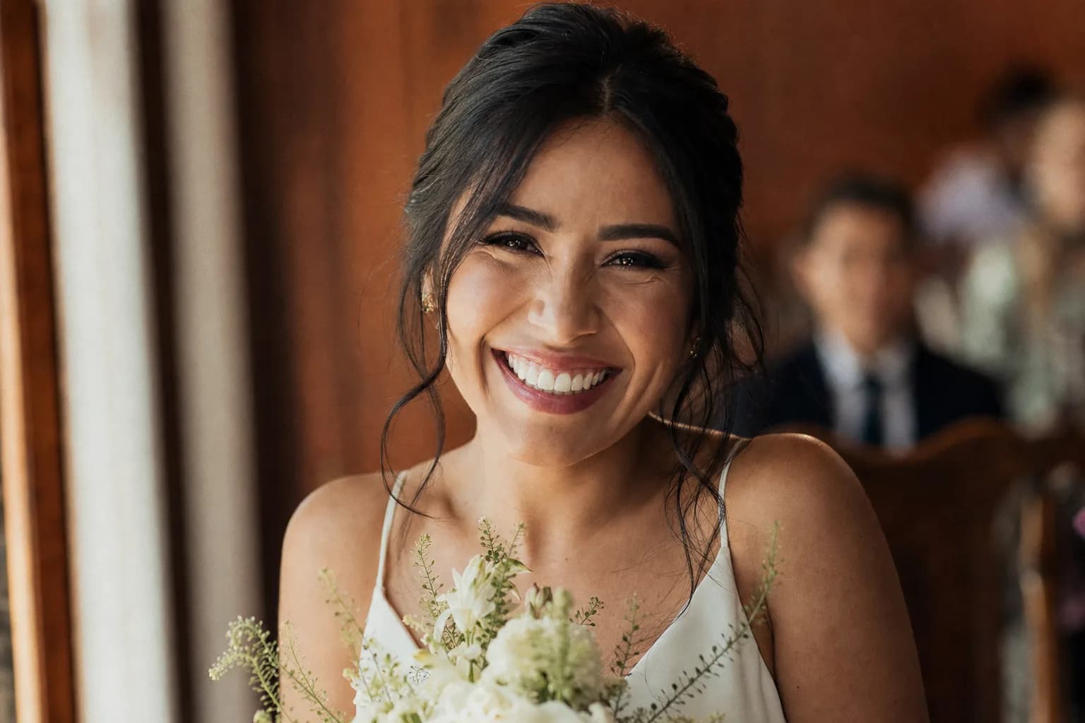 Novia sonriente en su boda civil con vestido blanco sencillo y ramo pequeno, luz natural calida